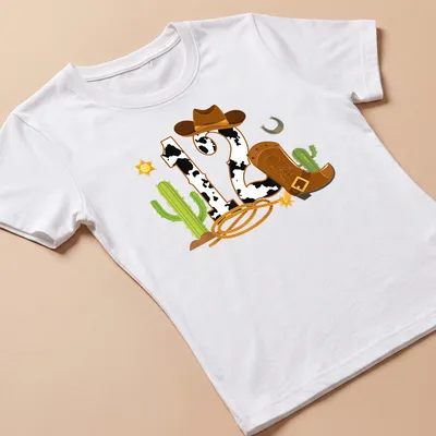 Colorful cartoon cowboy elements with a large '12' for birthdays — printed on a women's shirt