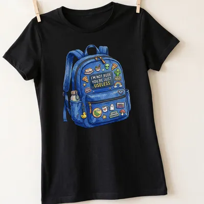 Colorful cartoon t-shirt with backpack stickers and the text 'I'M NOT RUDE. YOU'RE JUST USELESS' — printed on a women's shirt