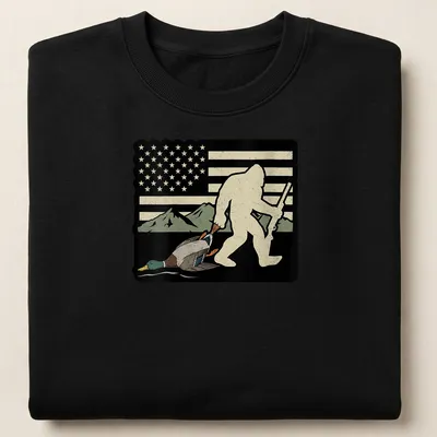 Whimsical Bigfoot carrying a duck with American flag elements in vintage style — printed on a unisex sweatshirt
