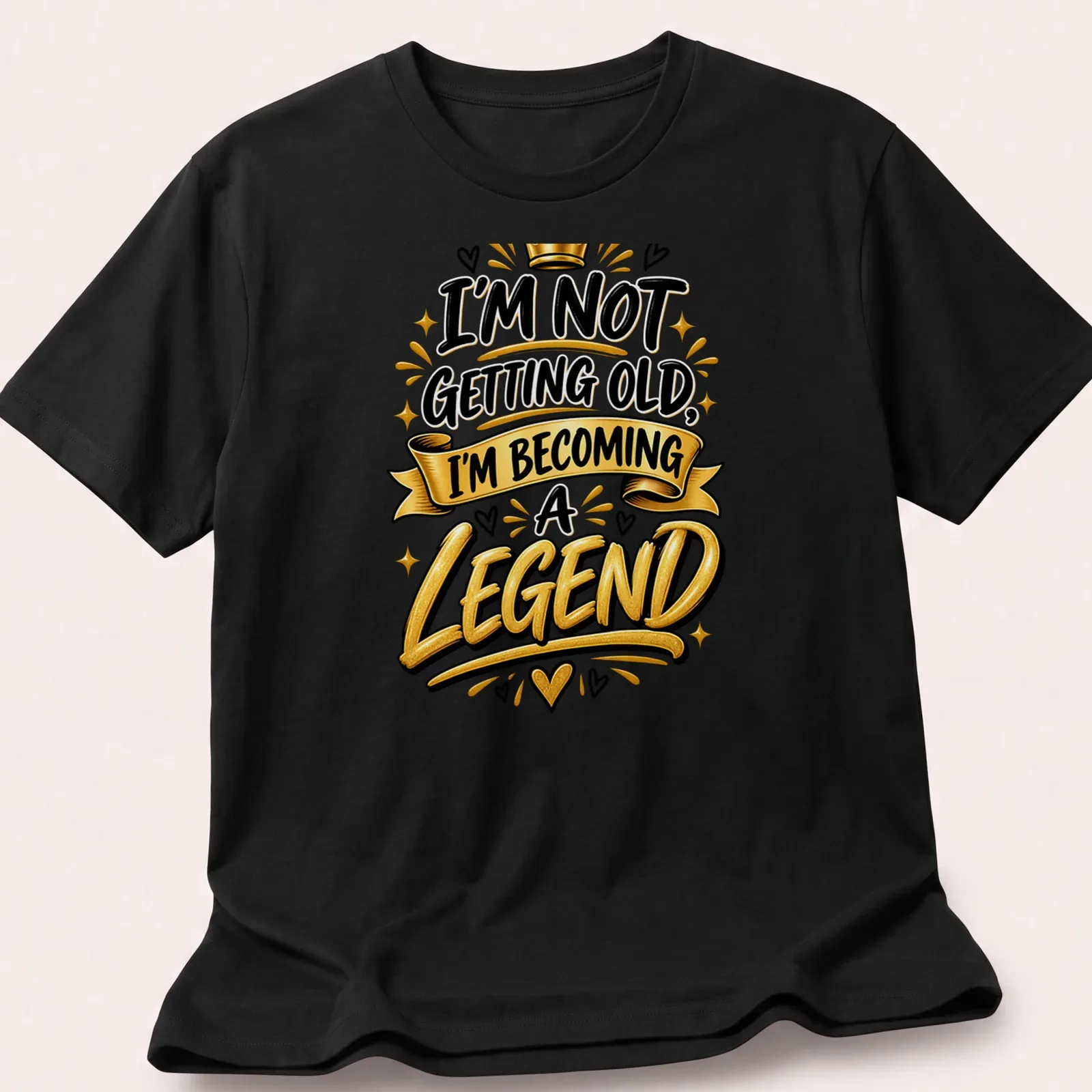 Bold typography t-shirt with the text I'm Not Getting Old, I'm Becoming a Legend in black, gold, and white. — printed on a unisex t-shirt