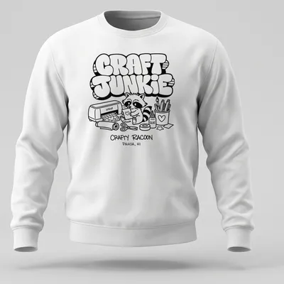 Cartoon raccoon graphic with text 'CRAFT JUNKIE CRAFTY RACOON PAHOA, HI' in black and white — printed on a unisex sweatshirt