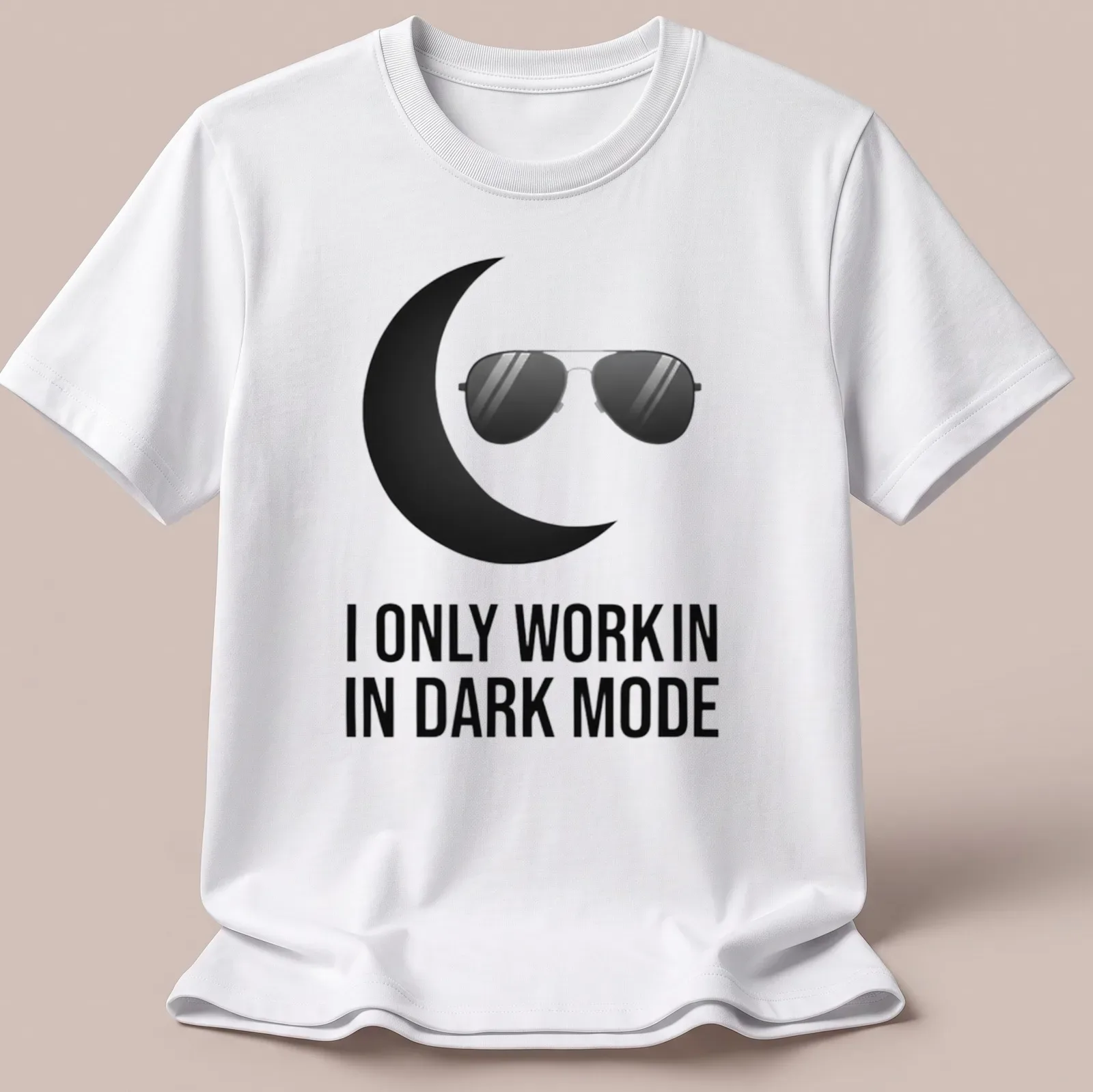 Minimalist design with black sunglasses and crescent moon above the text 'I ONLY WORK IN DARK MODE' — printed on a unisex t-shirt