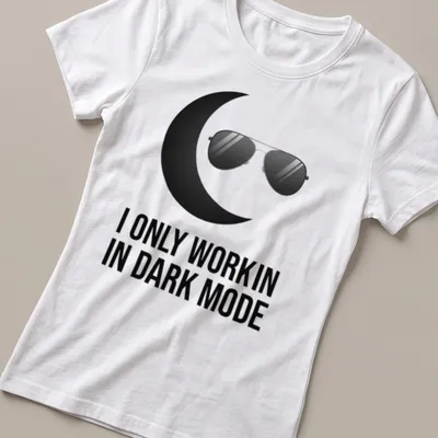 Minimalist design with black sunglasses and crescent moon above the text 'I ONLY WORK IN DARK MODE' — printed on a women's shirt