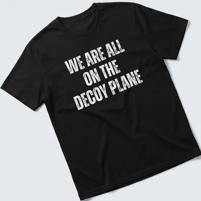 Bold typography on a t-shirt with the slogan 'WE ARE ALL ON THE DECoy PLANE' in white.
