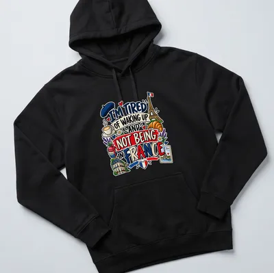 Colorful cartoon of Eiffel Tower, croissant, and coffee with text about France — printed on a unisex hoodie