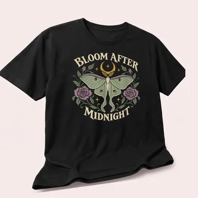 Gothic Luna Moth t-shirt with the text 'BLOOM AFTER MIDNIGHT' and a detailed moth illustration — printed on a unisex t-shirt (angled view)