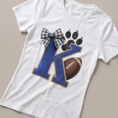 Vintage distressed shirt featuring a letter K, football, and paw print in blue and brown — printed on a women's shirt