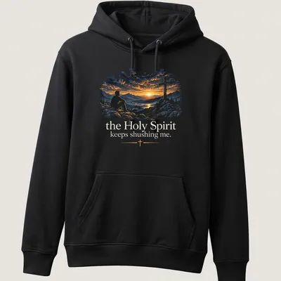 A serene illustration of a man on rocks at sunset with cross and text about the Holy Spirit — printed on a unisex hoodie