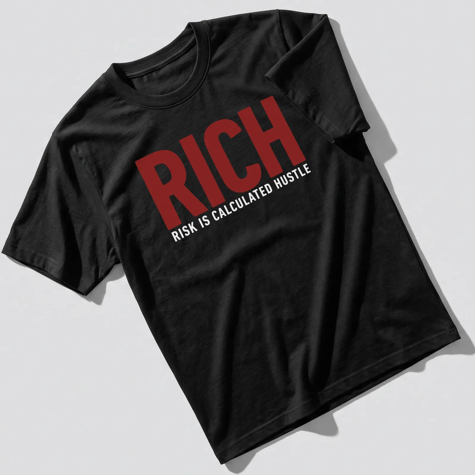 Bold typography t-shirt featuring the phrase 'Rich Risk Is Calculated Hustle' in maroon and white. — printed on a unisex t-shirt
