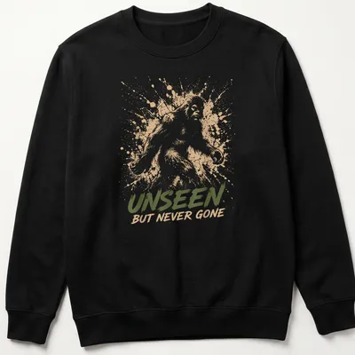 Sasquatch silhouette with splash art style and text 'Unseen But Never Gone.' — printed on a unisex sweatshirt