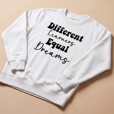 Bold typography Teacher shirt with the phrase Different Learners Equal Dreams printed in black. — printed on a unisex sweatshirt