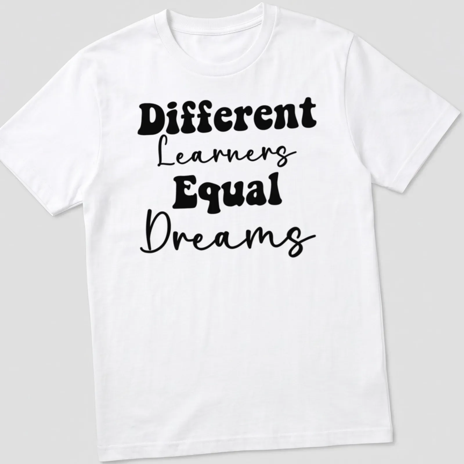 Bold typography Teacher shirt with the phrase Different Learners Equal Dreams printed in black. — printed on a unisex t-shirt