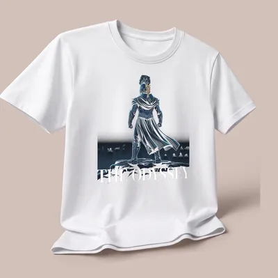 Detailed illustration of a warrior in armor atop a cliff with text: THE ODYSSEY — printed on a unisex t-shirt (angled view)