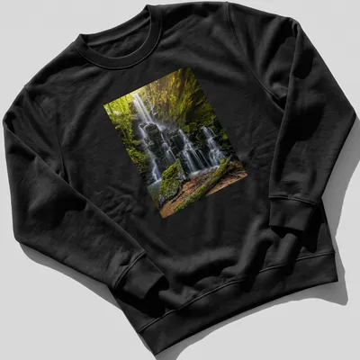 Photographic print of a waterfall surrounded by lush greenery in earthy tones — printed on a unisex sweatshirt