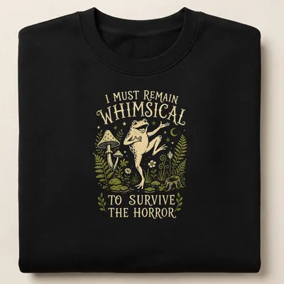 Whimsical illustration of a frog with the text 'I Must Remain Whimsical To Survive The Horror' — printed on a unisex sweatshirt