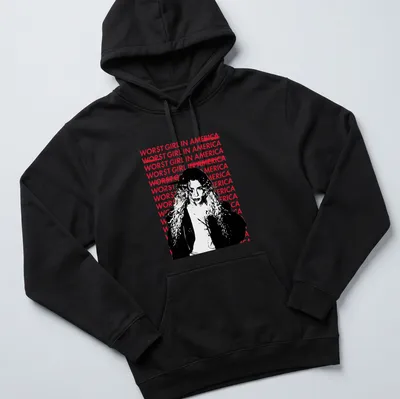 Bold graphic tee featuring the text 'WOR$T GIRL IN AMERICA' with an illustration of a woman with curly hair. — printed on a unisex hoodie